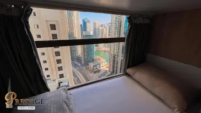 a bedroom with a window with a view of a city at Prestige holiday home Bed space in Dubai