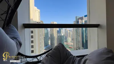a person laying in a hammock looking out of a window at Prestige holiday home Bed space in Dubai