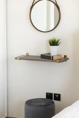 a mirror and a stool on a shelf in a bedroom at Frank Porter - Collective Tower 1 in Dubai
