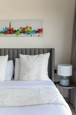 a bedroom with a bed with a painting on the wall at Frank Porter - Collective Tower 1 in Dubai