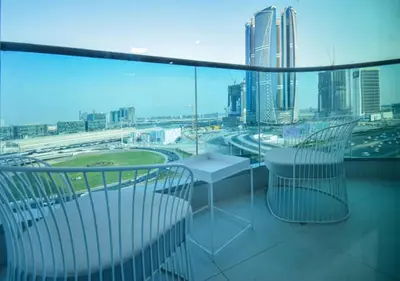a balcony with two chairs and a view of a city at Elegant 2BR view with rooftop pool The Bay in Dubai