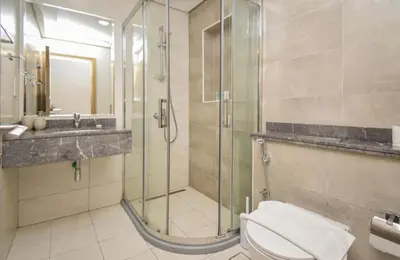 a bathroom with a shower and a toilet and a sink at Elegant 2BR view with rooftop pool The Bay in Dubai