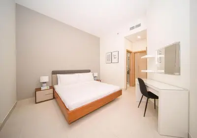 a white bedroom with a bed and a desk at Elegant 2BR view with rooftop pool The Bay in Dubai