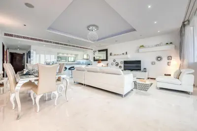 a living room with white furniture and a dining room at Tiara Residence Ruby, Palm Jumeirah - Mint Stay in Dubai