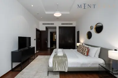 a bedroom with a white bed and a tv at Tiara Beach Residences, Palm Jumeirah Dubai - Mint Stay in Dubai