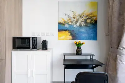 a living room with a table and a painting on the wall at Vacay Lettings - Waterfront Luxury home with full Marina view in Dubai