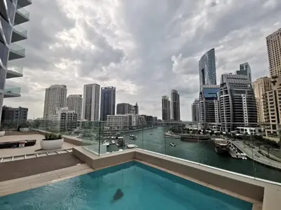 a swimming pool on the roof of a building with a city at Vacay Lettings - Waterfront Luxury home with full Marina view in Dubai
