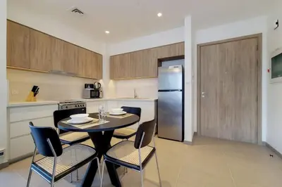 a kitchen with a table and chairs and a refrigerator at Vacationer I Executive 1 Bedroom I Free Parking & Wi-Fi in Dubai
