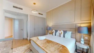 a bedroom with a large bed with a wooden headboard at Vacationer I Glamorous 2 Bedroom I Steps from Barasti Beach I Marina Views in Dubai