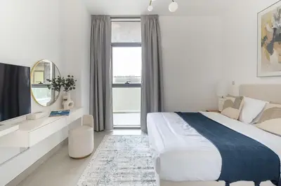 a white bedroom with a large bed and a window at Frank Porter - Pulse C2 in Dubai