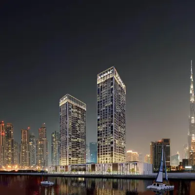 two tall skyscrapers in a city at night at DAMAC MAISON PRIVE - Deluxe Studio With Balcony & Water Canal View in Dubai