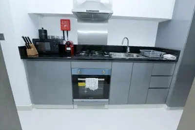 a small kitchen with a stove and a sink at DAMAC MAISON PRIVE - Deluxe Studio With Balcony & Water Canal View in Dubai