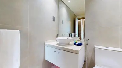 a white bathroom with a sink and a toilet at Stylish Apartment Balcony and Sea Views in Dubai