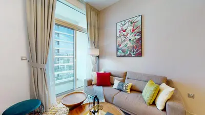 a living room with a couch and a large window at Stylish Apartment Balcony and Sea Views in Dubai