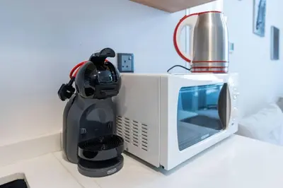 a microwave sitting on a counter next to a blender at Perfect 2br for families in JVC in Dubai