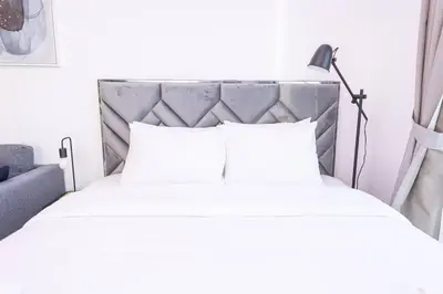 a bed with white pillows and a lamp at Royal Oceanic in JBR by HAPPY SEASON in Dubai