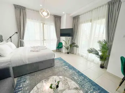 a bedroom with a bed and a room with windows at Royal Oceanic in JBR by HAPPY SEASON in Dubai