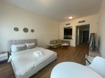 a bedroom with a large bed and a living room at Stylish Studio in Discovery Garden MED100 in Dubai