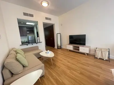 a living room with a couch and a flat screen tv at Stylish Studio in Discovery Garden MED100 in Dubai