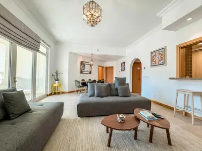 a living room with two couches and a table at Upgraded 2BR apartment at the beach - Shoreline 1 in Dubai