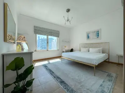 a bedroom with a bed and a large window at Upgraded 2BR apartment at the beach - Shoreline 1 in Dubai
