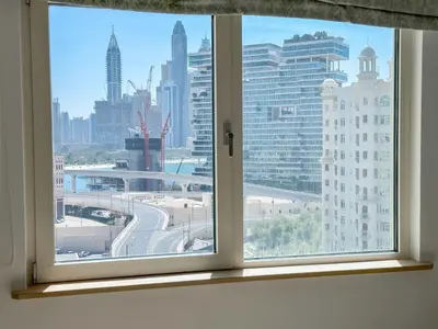 a window with a view of a city skyline at Upgraded 2BR apartment at the beach - Shoreline 1 in Dubai