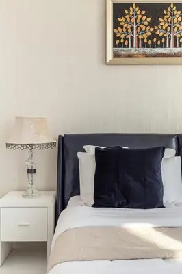 a bed with a blue headboard and a table with a lamp at Frank Porter - Starz by Danube in Dubai