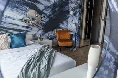 a bedroom with a bed and a chair and a mirror at GuestReady - Luxe Suite in Jumeirah Marina in Dubai