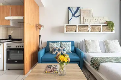 a living room with a blue couch and a table at Frank Porter - Marina Views T1 in Dubai