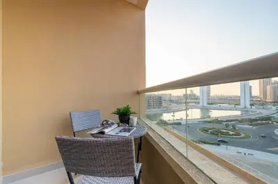a balcony with a table and chairs and a large window at Frank Porter - Lakeside Tower D in Dubai