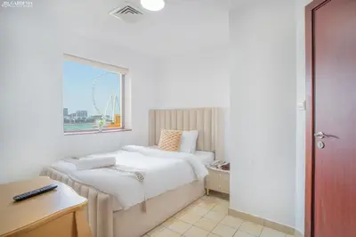 a hotel room with a bed and a window at JBR - Apartment plus maid in Dubai