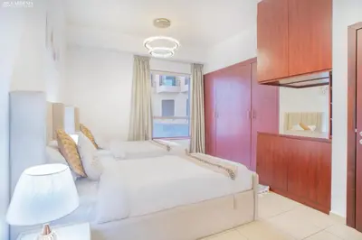 a bedroom with a white bed and a window at JBR - Apartment plus maid in Dubai