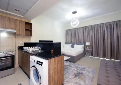 a kitchen and living room with a bed and a stove at RH- Voguish, Studio in Downtown, short walk to Burj Khalifa in Dubai
