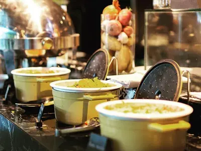 a table with bowls and plates of food on it at Cosmos Living Elegant Studio Near Dubai Marina in Dubai