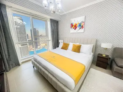 a bedroom with a bed and a large window at Cosmos Living Elegant Studio Near Dubai Marina in Dubai