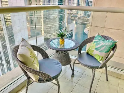 a table and chairs on a balcony with a view at White Sage - Lakefront Apartment Amidst Parks With Lake Access in Dubai
