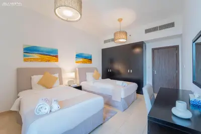a hotel room with two beds and a desk at JBR - Shams Suites - Sea & Marina View Walking Distance to The Beach by Gardenia in Dubai