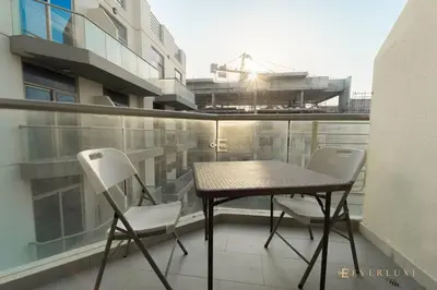 a balcony with a table and two chairs on a balcony at Everluxe Azizi Montrell Lovely Studio in Dubai