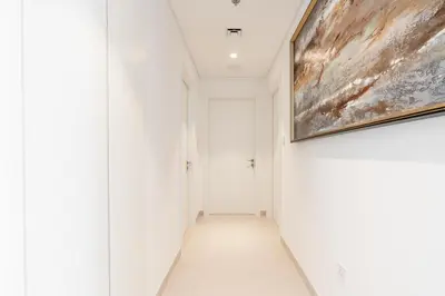 a hallway with white walls and a painting on the wall at Lux BnB The Grand Creek Harbor Views in Dubai