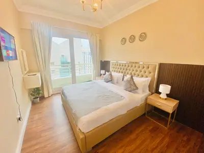 a bedroom with a large bed with a large window at Manchester Regency - 2BR Apartment in Dubai Marina in Dubai