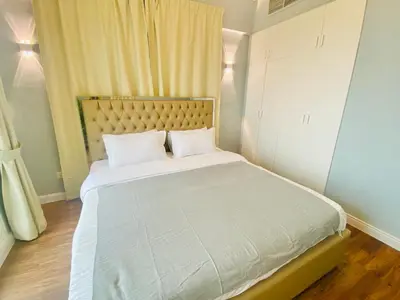 a bedroom with a large bed with white sheets at Manchester Regency - 2BR Apartment in Dubai Marina in Dubai