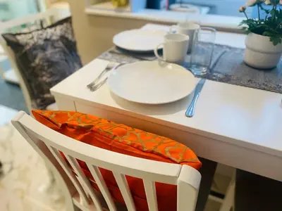 a table with two plates and a chair with a napkin at Manchester Regency - 2BR Apartment in Dubai Marina in Dubai