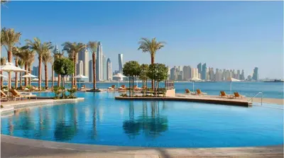 a large swimming pool with palm trees and a city at Luton Vacation Homes - Luxury & Spacious 1BR North Residence Fairmont , Palm Jumeirah - 90AB3 in Dubai