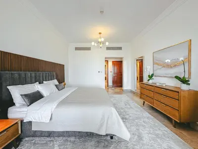 a bedroom with a large bed and a wooden dresser at Luton Vacation Homes - Luxury & Spacious 1BR North Residence Fairmont , Palm Jumeirah - 90AB3 in Dubai