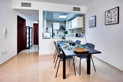 a dining room and kitchen with a table and chairs at Big sea view studio in JBR in Dubai