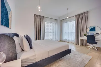 a bedroom with a bed and a desk with a chair at Nice and comfy 2BD apartment in Jbr in Dubai