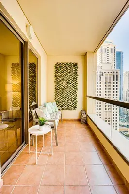a balcony with a couch and a table at Nice and comfy 2BD apartment in Jbr in Dubai