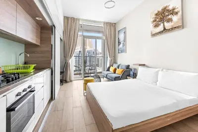 a small bedroom with a bed and a kitchen at ALiving Cozy Studio with Canal View I Studio One, Dubai Marina in Dubai