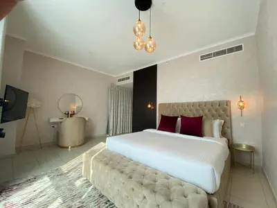 a bedroom with a large white bed with red pillows at Durrani Homes - The Residences 5BR Besides Dubai Mall with Burjkhalifa and Fountain view in Dubai