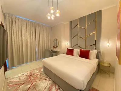 a bedroom with a large white bed with red pillows at Durrani Homes - The Residences 5BR Besides Dubai Mall with Burjkhalifa and Fountain view in Dubai
